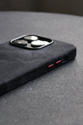 Close-up of a black phone case with red accents on a gray surface