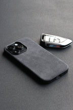 Gray phone case and car key on a gray surface