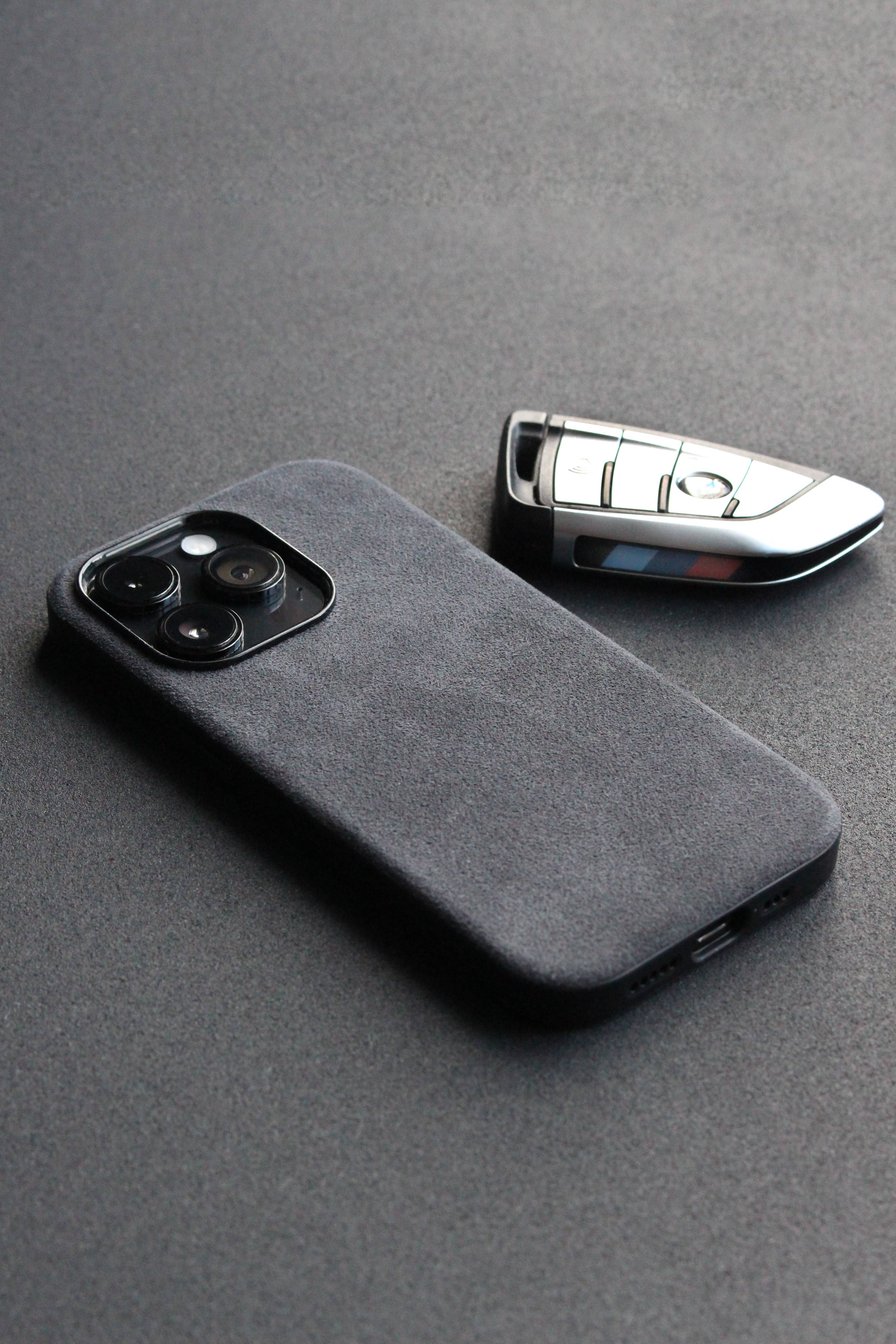 Gray phone case and car key on a gray surface