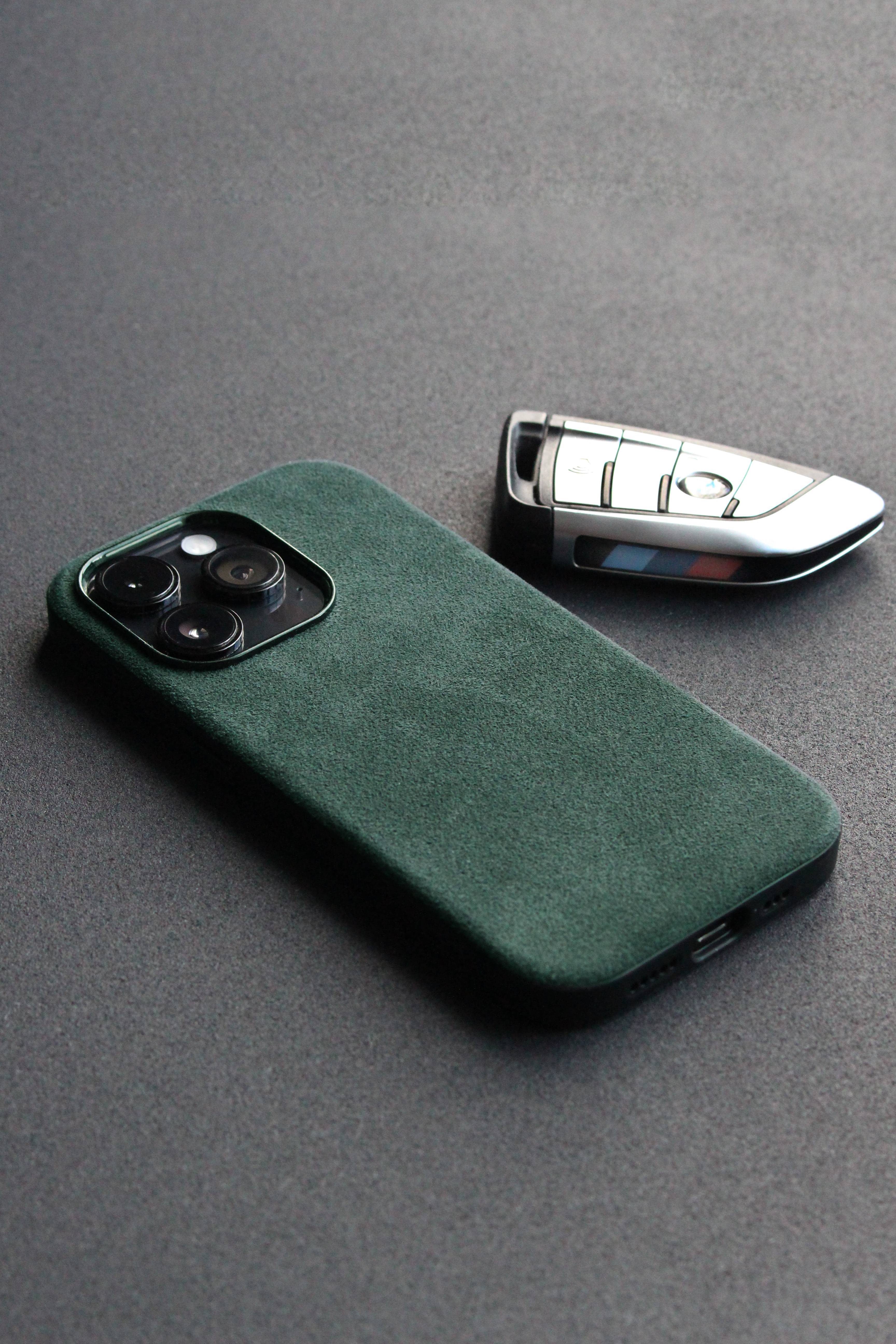 Green phone case and car key on a gray surface